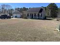 Exterior view of a well-maintained home and garage with a large front yard, surrounded by lush trees in the distance at 113 Cat Tail Bay Dr., Conway, SC 29527
