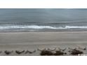 A serene view of the sandy beach meeting the ocean's edge, with gentle waves rolling in at 1501 S Ocean Blvd. # 935, Myrtle Beach, SC 29577