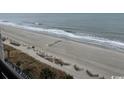 Expansive view of the sandy beach, gentle waves, and horizon from a high vantage point at 1501 S Ocean Blvd. # 935, Myrtle Beach, SC 29577