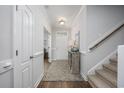 Bright entryway featuring hardwood floors, stairs to the right, and a charming console table at 172 Board Landing Circle, Conway, SC 29526