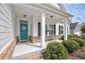 Inviting front porch with brick accents, white columns, and a charming teal door at 172 Board Landing Circle, Conway, SC 29526