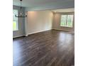 Large living room featuring luxury vinyl plank flooring, fresh paint, and modern light fixtures at 183 Glengrove Lane, Murrells Inlet, SC 29576