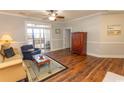 Bright living room with wood floors, neutral paint, comfortable seating and wood cabinet at 2241 Waterview Dr. # 227, North Myrtle Beach, SC 29582