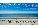 Stunning aerial view of a sandy beach lined with blue umbrellas, meeting the beautiful turquoise ocean at 2500 N Ocean Blvd. # 705, North Myrtle Beach, SC 29582