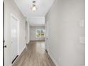 Hallway featuring wood-look flooring and white doors, leading to various rooms in the home at 351 Lakota Loop, Longs, SC 29568