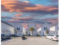 Row of modern, white houses with a shared parking area and vibrant sunset backdrop at 3511 Fountain Ln., Myrtle Beach, SC 29577