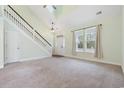 Bright living room features high ceilings, a staircase, and large windows that offer plenty of natural light at 395 Dunbarton Ln., Conway, SC 29526