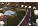 Aerial view of community pool, tennis courts, lake, and clubhouse surrounded by lush landscaping at 523 Oak Landing Dr., Myrtle Beach, SC 29588
