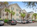 Beautiful condo complex showcasing multiple levels, white balconies, and lush green trees at 601 Hillside Dr. # 4233, North Myrtle Beach, SC 29582