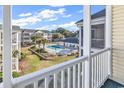 View of a pristine community pool surrounded by manicured lawns and lush greenery from a private balcony at 601 Hillside Dr. N # 3031, North Myrtle Beach, SC 29582