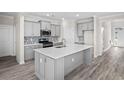 Modern kitchen with an island and stainless steel appliances, adjacent to additional living spaces at 619 Castle Ct., Myrtle Beach, SC 29579