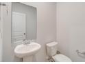 A half bathroom with a pedestal sink, toilet, mirror, and towel bar at 985 Laconic Dr., Myrtle Beach, SC 29588