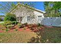 Landscaped backyard featuring mulch beds, decorative bushes, and a classic white fence for added privacy at 152 Rose Water Loop, Myrtle Beach, SC 29588