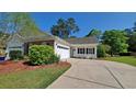 Charming home with a two-car garage, front porch, beautiful landscaping, and a paved driveway at 152 Rose Water Loop, Myrtle Beach, SC 29588