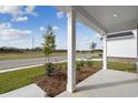 Inviting front porch with white pillars and a view of the landscaped front yard and neighborhood street at 2416 Campton Loop, Conway, SC 29527