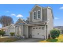 Charming two-story home showcasing a gray exterior, white garage door, and beautifully landscaped front yard at 314 Lyons Cove Dr., Myrtle Beach, SC 29577