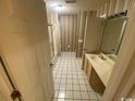 Bathroom featuring a shower-tub combo, white tile flooring, vanity with sink, and door leading to other rooms at 330 S Middleton Dr. # 306, Calabash, NC 28467