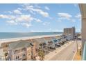 Beautiful view of the ocean from a balcony with beachfront homes and partly cloudy skies at 4103 N Ocean Blvd. # 207, North Myrtle Beach, SC 29582