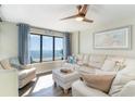 Living room with view of the ocean, an armchair, and a large white couch at 4103 N Ocean Blvd. # 207, North Myrtle Beach, SC 29582