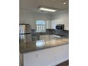 Well-lit kitchen featuring stainless steel appliances, granite countertops, and white cabinetry at 4155 Hibiscus Dr. # 103, Little River, SC 29566