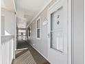 Exterior hallway leading to unit with covered walkway, natural light, and neutral color scheme at 4420 Eastport Blvd. # M12, Little River, SC 29566