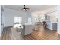 Bright open-concept living area with hardwood floors, a ceiling fan, and views of the kitchen at 481 Morning Glory Ct., Myrtle Beach, SC 29579