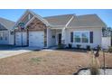 Well-maintained home featuring a two-car garage, manicured lawn, and inviting curb appeal on a sunny day at 568 Canborough Lane, Murrells Inlet, SC 29576