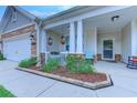 Inviting front porch with stone accents and a cozy seating area, enhanced by well-maintained landscaping at 676 Lafayette Park Dr., Little River, SC 29566