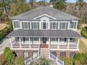 Stately home features a large front porch, pristine landscaping, and a striking metal roof accent at 80 Stonington Dr., Murrells Inlet, SC 29576