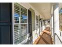Covered porch featuring classic columns, wood flooring, and charming black shutters and lanterns at 80 Stonington Dr., Murrells Inlet, SC 29576