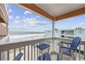 Enjoy ocean views from this balcony with blue Adirondack chairs and table at 900 N Waccamaw Dr. # 303, Murrells Inlet, SC 29576