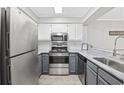 Updated kitchen featuring stainless steel appliances, white cabinets, and stone countertops at 900 N Waccamaw Dr. # 303, Murrells Inlet, SC 29576