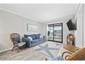 Cozy living room with comfortable seating, a starfish rug, and a sliding door to the balcony at 900 N Waccamaw Dr. # 303, Murrells Inlet, SC 29576