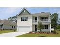 Charming two-story home boasts white siding, a balcony, and a well-manicured front lawn at 104 Fair Meadow Ct., Loris, SC 29569