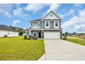 Two-story home with stone accents, a two-car garage, and a well-manicured lawn at 1064 Jase Dr., Longs, SC 29568