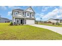 Beautiful two-story home with a well-kept lawn and a long driveway at 1064 Jase Dr., Longs, SC 29568