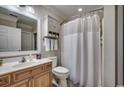 Well-lit bathroom with a shower featuring a curtain, and a wooden vanity with a sink and a decorative mirror at 123 Avian Dr. # 102, Pawleys Island, SC 29585