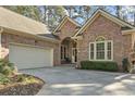 Charming brick home featuring a well-manicured lawn, mature trees, and an attached two-car garage at 17 Montrose Ln., Pawleys Island, SC 29585