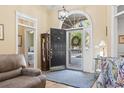 Elegant foyer with a dark wood door, chandelier, and hardwood floors at 17 Montrose Ln., Pawleys Island, SC 29585