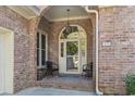 Inviting brick porch with seating and a decorative wreath on the front door at 17 Montrose Ln., Pawleys Island, SC 29585