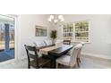 Dining area with a wood table, neutral chairs, a modern chandelier, and a view to the exterior at 1833 Hardwood Ct., Conway, SC 29526