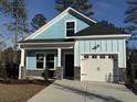 Charming light blue two-story home with stone accents, an attached garage, and well-manicured landscaping at 3121 Tiger Tail Rd., Conway, SC 29526