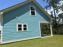Corner of a light blue home with a covered patio showing window details at 3121 Tiger Tail Rd., Conway, SC 29526