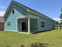 Rear exterior of a light blue home with a covered patio and sliding glass doors at 3121 Tiger Tail Rd., Conway, SC 29526
