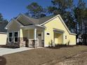 Charming one-story yellow home with stone accents and a welcoming front entrance at 3135 Tiger Tail Rd., Conway, SC 29526