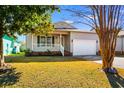 Inviting home featuring a cozy front porch and a well-maintained lawn at 3816 James Pl., Little River, SC 29566