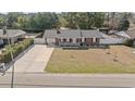 An aerial view of a single-story brick house with a fenced yard and a long concrete driveway at 4048 Sandtrap Ave., Little River, SC 29566