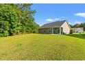 Expansive backyard with well-maintained lawn, patio, and mature trees offering privacy and space for outdoor activities at 825 Payne Ct., Conway, SC 29526