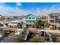 Aerial view showcasing the blue coastal home, boat docks and neighborhood at 84 Wilmington St., Ocean Isle Beach, NC 28469