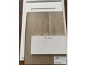 An arrangement of samples including white cabinets, wood flooring, and Elusive White countertop material at 990 Oak Hollow St., Longs, SC 29568